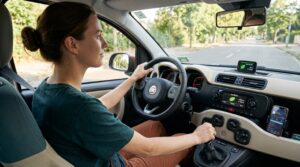 Junge Person am Steuer eines Kompaktwagens während einer eco-orientierten Fahrt